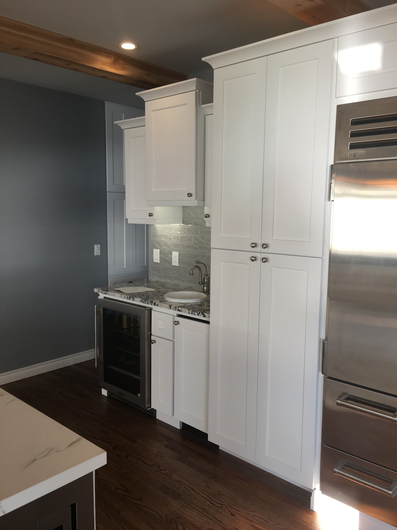 Tall kitchen cabinetry with installed refrigerator and beverage cooler