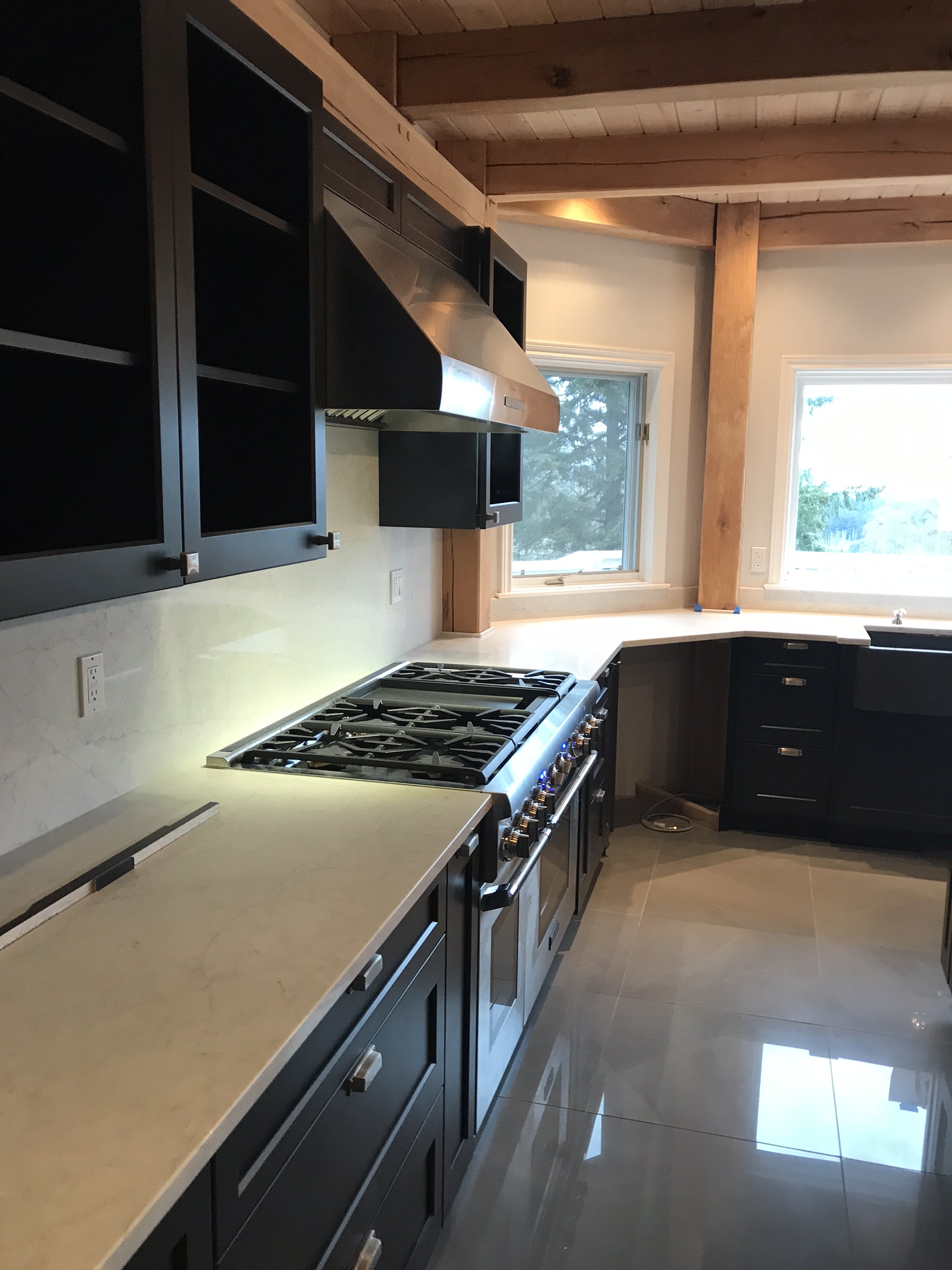 Finished kitchen counter and cooking area with black cabinetry