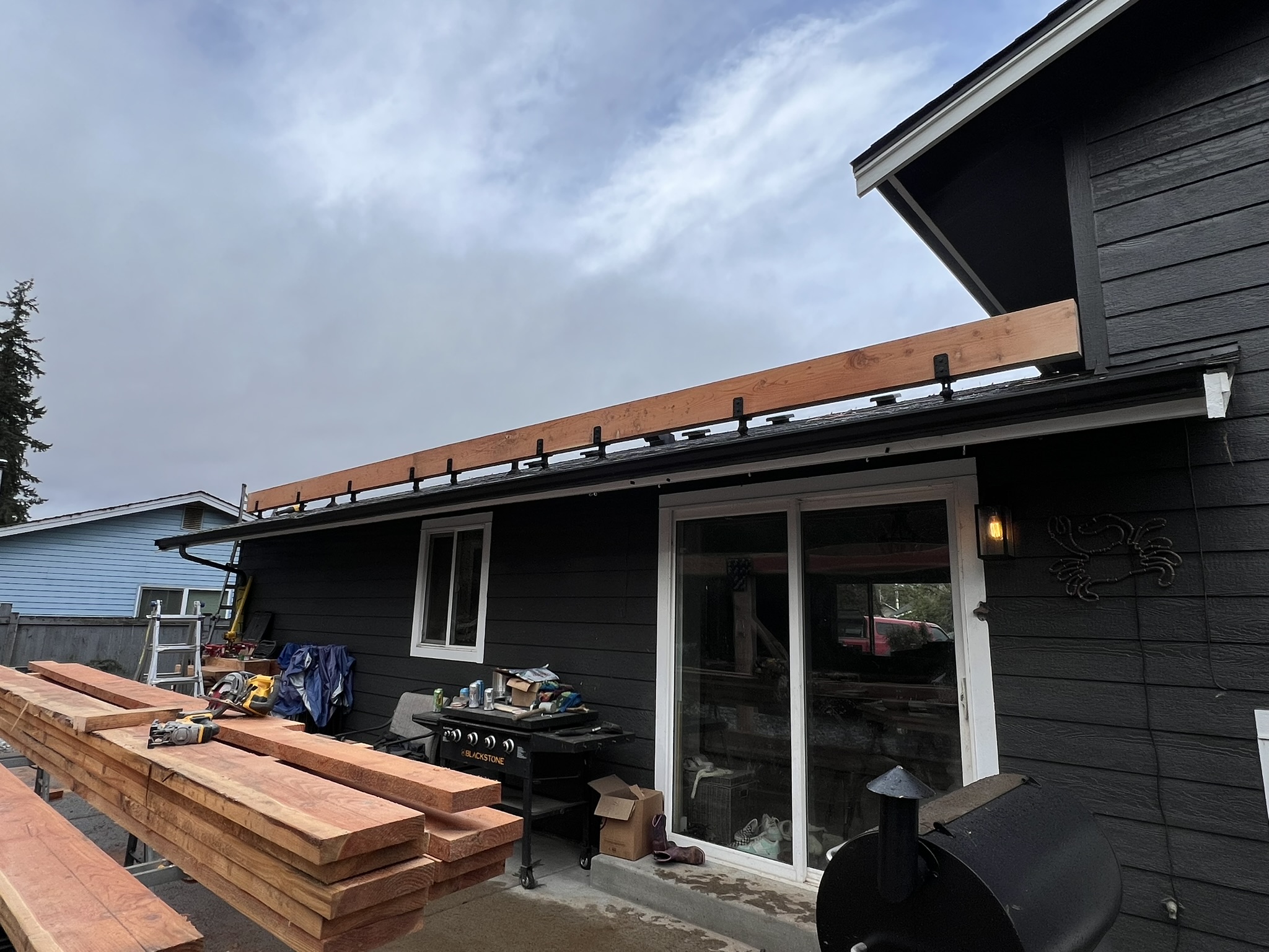 Patio cover construction beginning along the rear of the home