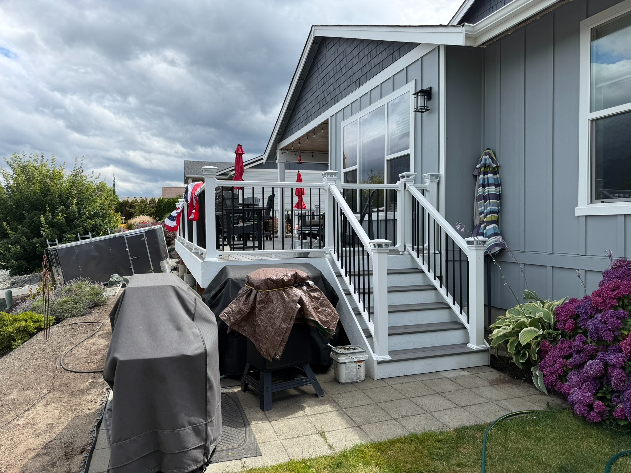 Side view of the finished deck with new white and black railing
