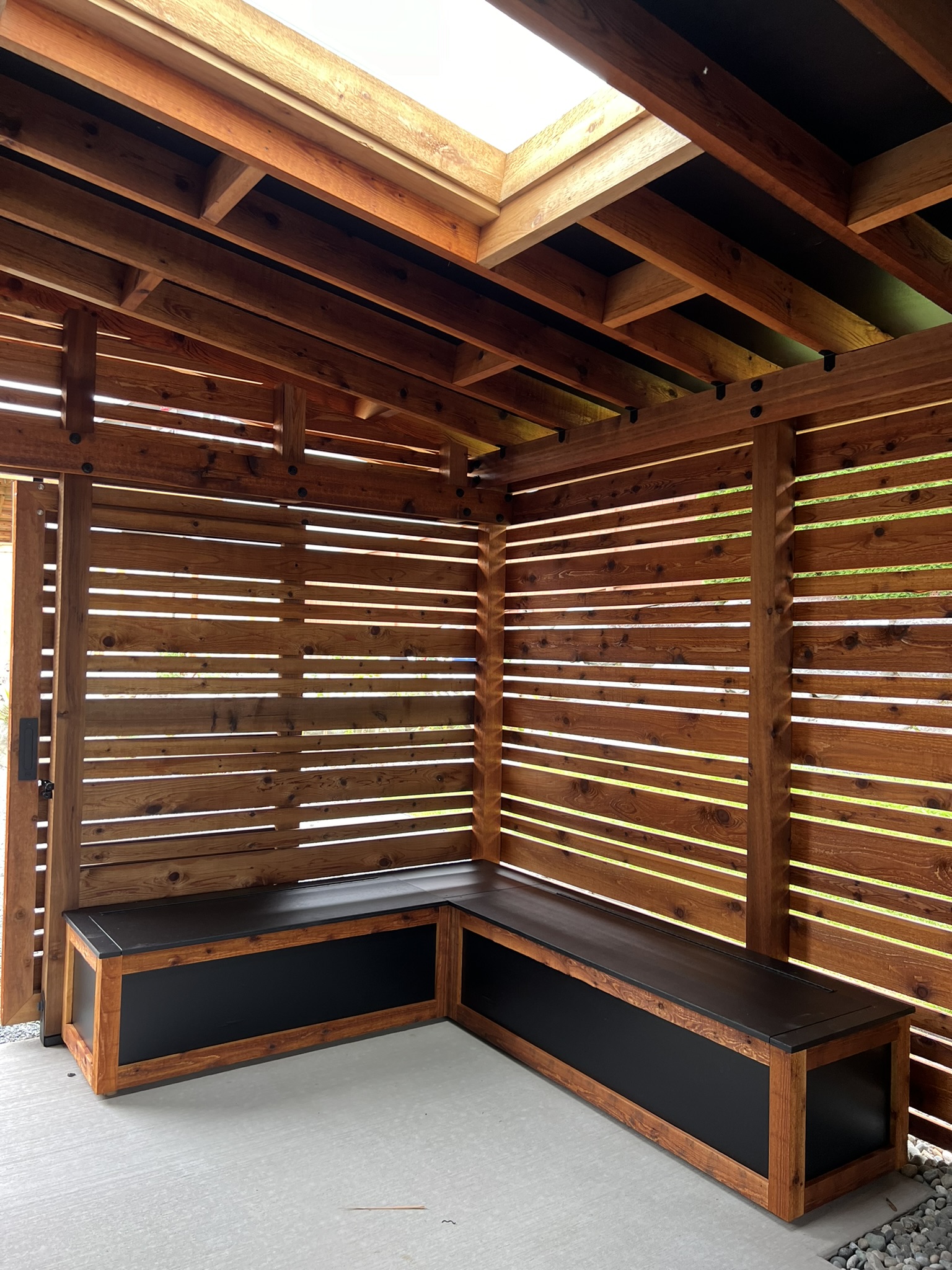 Built-in storage bench installed beneath the slatted garden-room walls