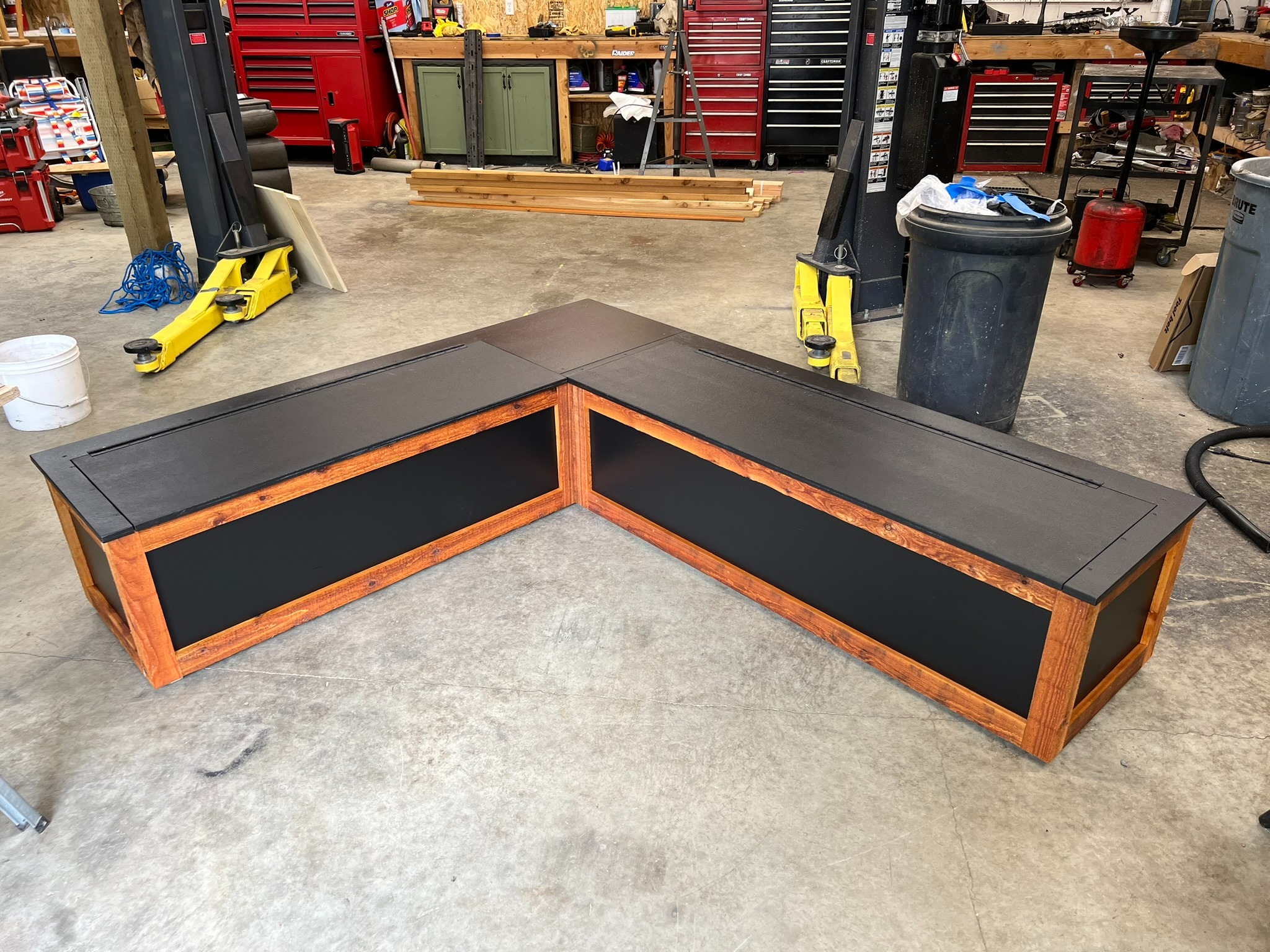 Completed L-shaped wood storage bench in the workshop